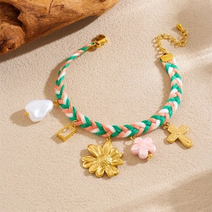 Detail of bohemian handmade woven bracelet with colorful cords and mixed golden charms