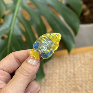 Close-up of a mini yellow acrylic tropical fish hair clip with sparkling blue rhinestones