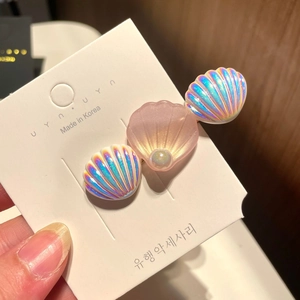 Detail of mermaid shell hair clip with iridescent luster and central pearl accent