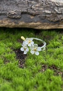 Macro detail of S925 sterling silver forget-me-not flower ring with gold-plated accents