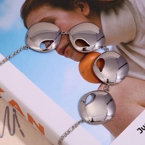Macro detail of silver mirror polished notched round pendants on an artistic background