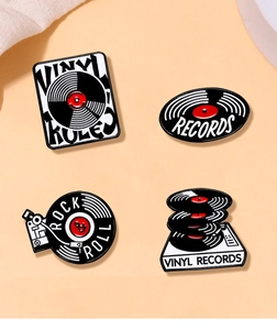 Set of four vintage vinyl record enamel pins featuring retro rock and roll music motifs