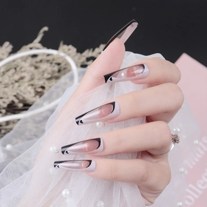 Long ballet press-on nails with black and white heart French design on model hand