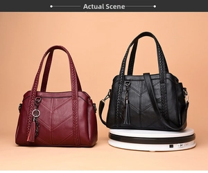 Detail of soft leather handbags with V-quilted texture and woven handles in red and black