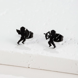 Detail shot of matte black cupid angel silhouette stud earrings on white stone display