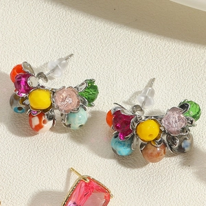 Macro detail of bohemian stud earrings with colorful crystals and mixed stone beads