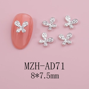 Macro shot of 8x7.5mm hollow butterfly nail charms with silver finish and shiny rhinestones