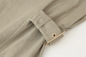 Macro view of khaki linen fabric texture with decorative gold metal ring fastener detail