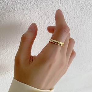 Close-up of irregular wave texture on a gold plated S925 sterling silver ring worn by a model