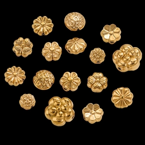 Detailed view of golden flower charms and spacer beads for DIY jewelry making