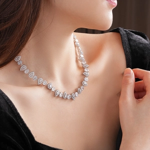 Close-up of elegant silver necklace with teardrop zircon stones on model neck