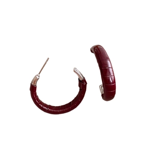 Créoles en C enveloppées de cuir rouge foncé avec tiges en argent sur fond blanc