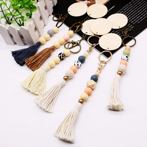Detail of boho beaded keychain with wooden disc, colorful cotton tassel, and alloy clasp