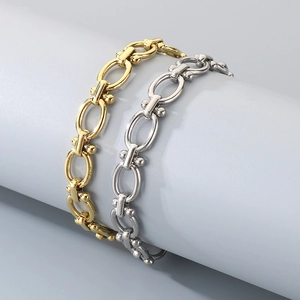 Gros plan de bracelets gourmettes dorés et argentés sur un support d'affichage minimaliste