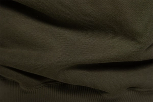 Macro detail of olive green cotton knit fabric and ribbed cuff texture on crewneck sweatshirt