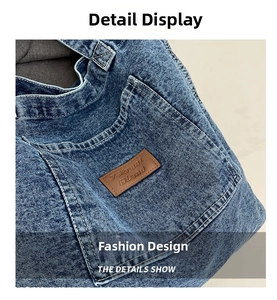 Close-up of washed blue denim fabric with stitching details and premium leather logo patch