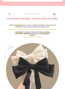Detail view of large black and cream ribbon bow hair clips in soft satin material