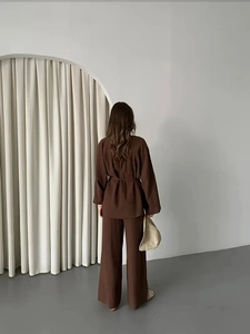 Completo elegante marrone con top a maniche lunghe e pantaloni larghi, vista posteriore