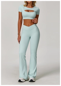 Detail view of light blue v-waist flared yoga pants and cutout short sleeve sports top