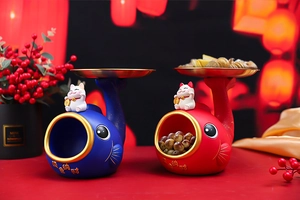 Detail of red and blue whale storage figurines with gold trays and Maneki-neko charms