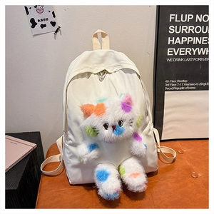 Dettaglio di un gatto di peluche su uno zaino in nylon bianco crema per donne e studenti