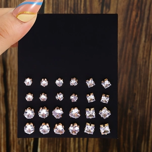 Set of 12 pairs of golden stud earrings with sparkling crystals on a display card