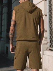 Rear view of men's sleeveless olive brown hooded tracksuit with cargo shorts in city street