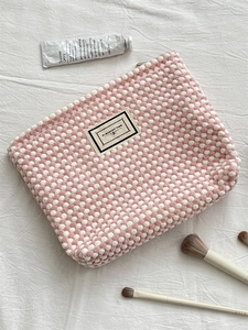 Detail of pink and white checkered makeup bag with zipper and large storage space