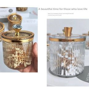 Detail of luxury ribbed glass storage jars with decorative lids and gold metal rims