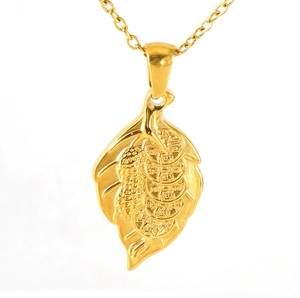 Détail macro du pendentif feuille en or 18 carats avec motifs de cacahuète et pièces
