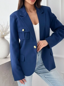 Dettaglio del blazer blu navy con bottoni dorati a rilievo e tasca sul petto con patta