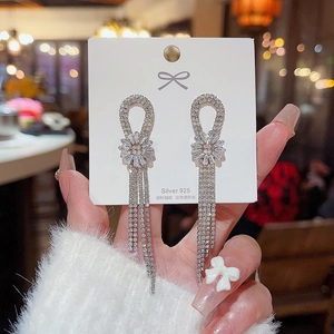 Macro shot of S925 silver needle dangle earrings with crystal fringe and floral details