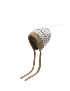 Detail der khakifarbenen Strickmütze mit ethnischen Mustern und Ohrenklappen