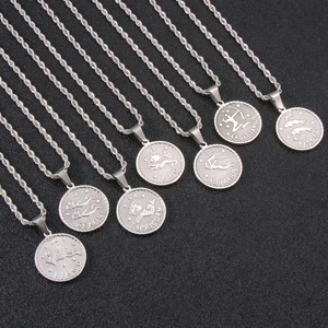 Detailed shot of seven silver zodiac coin pendants with engraved constellation names