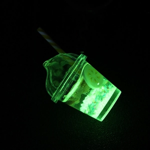 Glow in the dark bubble tea keychain cup with floating lemon slice in neon green light
