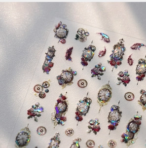 Macro shot of laser holographic vintage clock and floral embossed nail art stickers