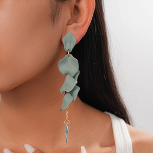 Close-up of vintage grey acrylic petal tassel earrings worn by a model in soft lighting