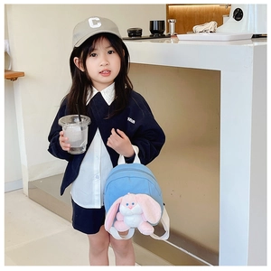 Sky blue kids backpack with cute pink plush bunny toy shown on child model