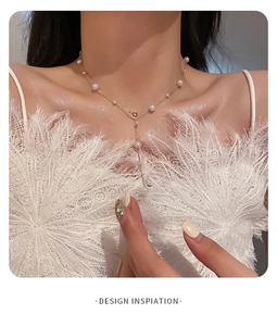 Detail of Y-shaped gold pearl necklace featuring elegant strand on model's neckline