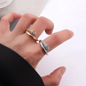 Snake-shaped open ring featuring ruby and emerald gemstone eyes with white zircon pave