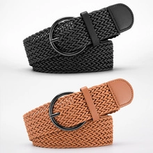 Detail of black and brown braided elastic belts with round buckles on white background
