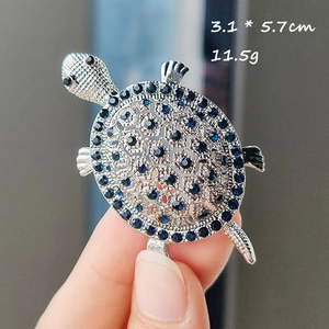 Detail showing a turtle brooch with blue crystals and silver finish, size 3.1x5.7cm