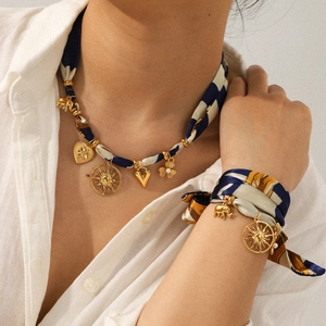 Silk scarf necklace and bracelet set with golden heart and elephant charms on a model