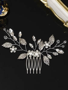 Detail of bridal hair comb with silver leaf patterns, rhinestones and white pearls