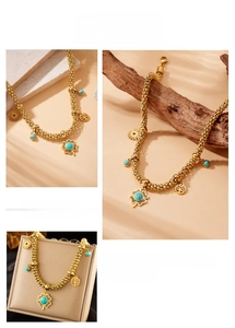 Detail of bohemian gold bead necklace with turquoise flower and tree of life charms
