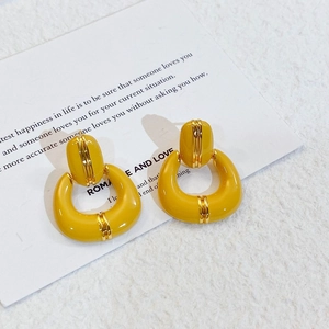 Detail of vintage U-shaped yellow enamel earrings with gold plating on poetic card