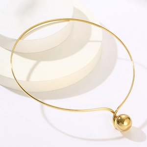 Minimalist gold stainless steel choker necklace with a spherical pendant on white prop