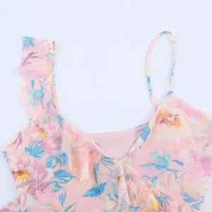 Dettaglio del top rosa floreale in mesh con volant asimmetrici e scollatura a V
