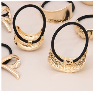 Detail view of various irregular golden alloy hair ties with geometric bow and arc designs