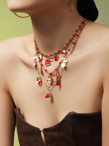 Detailed close-up of layered Christmas necklace with enamel Santa and snowman charms